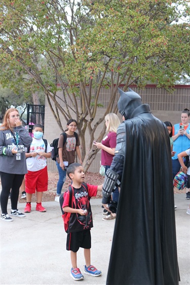 Batman talking to a child.