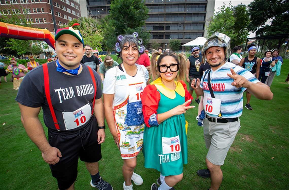 Three people in costumes posing for a photo at a race.