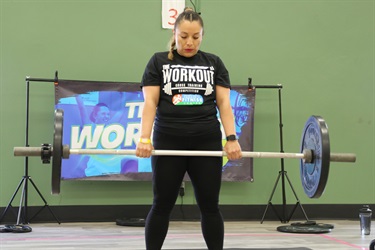 A woman in a gym lifting weights.
