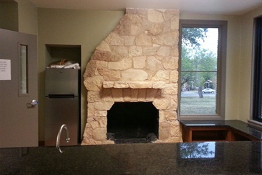 Charming stone fireplace in a room with a window, combining comfort and natural light for a serene atmosphere.