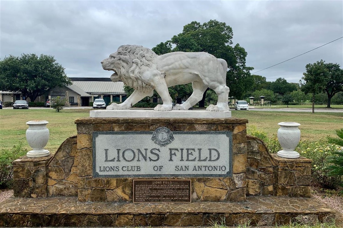 A lion statue on top of the Lions Field sign