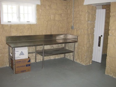 A metal table or counter space sits in the corner of the room.