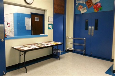 A classroom with blue doors and a table.