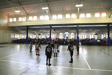 Kids playing basketball in a gymnasium during a Spurs kids league game.