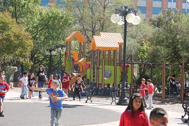 Children happily engaged in various activities, enjoying their time in a vibrant park setting.